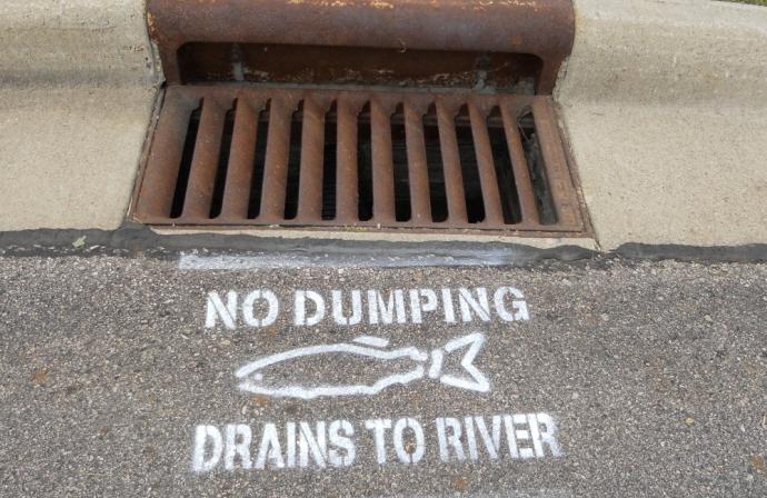 Storm drain with writing: No Dumping drains to River