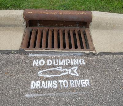Storm drain with writing: No Dumping drains to River